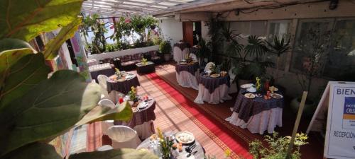 un grupo de mesas en una habitación con plantas en NEW HOTEL CRUZ DEL SUR, en Concepción