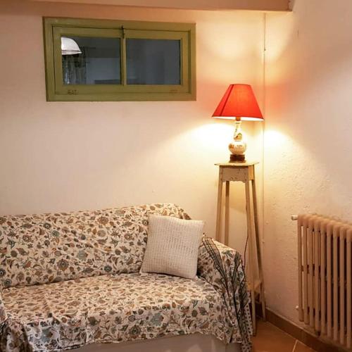 a living room with a couch and a lamp at Affittacamere Bocca d'Orso in Altare