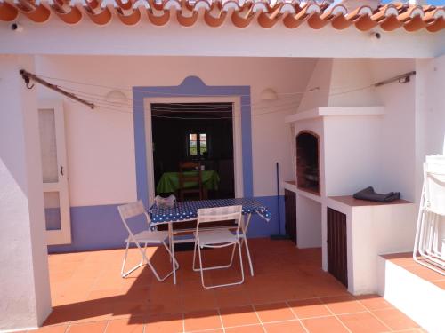a model of a house with a table and chairs at Vivenda com jardim no campo a 350 do Mar in Vila Nova de Milfontes