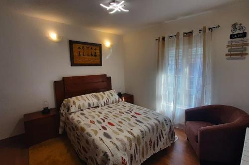 a bedroom with a bed and a chair at Piso céntrico con encanto in Santander