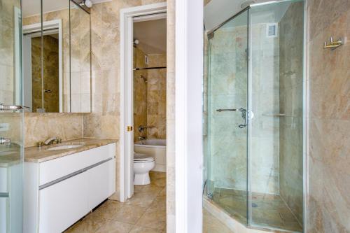 Un baño con ducha de cristal y un inodoro. en Sutton Place 2BR w Gym Pool DM nr Central Pk NYC-464, en Nueva York