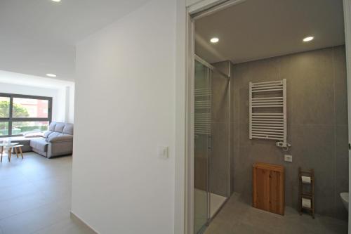 La salle de bains est pourvue d'une douche et d'un canapé. dans l'établissement Apart-rent Apartment Mimoses 0069, à Empuriabrava