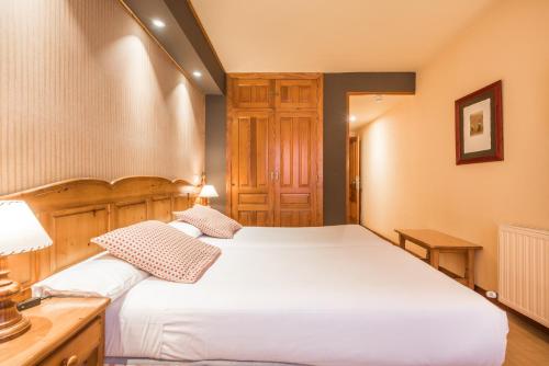 a bedroom with two beds and a wooden cabinet at Snö Villa de Sallent 3 in Formigal