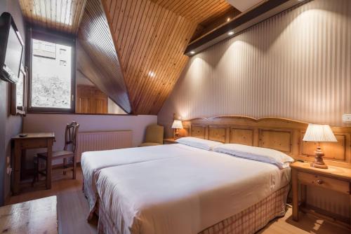 a bedroom with a bed and a desk and a window at Snö Villa de Sallent 3 in Formigal