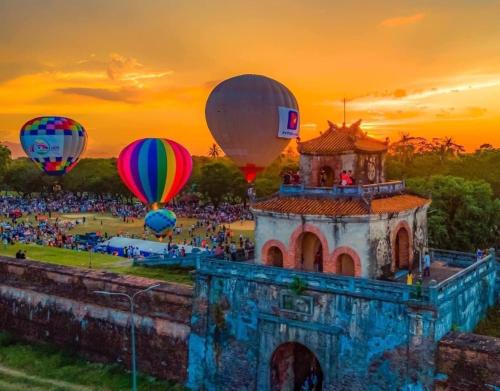 a group of hot air balloons flying over a castle at Moon Homestay in Thôn Kim Long (1)