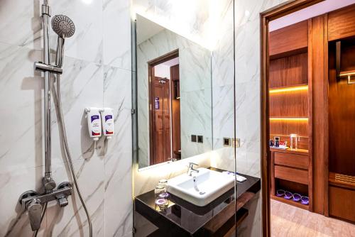uma casa de banho com um lavatório e um chuveiro em FOX HARRIS Hotel & Convention Banjarnegara em Banjarnegara