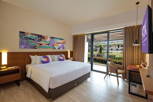 BanjarnegaraにあるFOX HARRIS Hotel & Convention Banjarnegaraの大型ベッドとテレビが備わるホテルルームです。