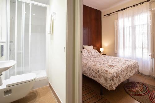 1 dormitorio con 1 cama y baño con lavamanos en El Jardí de Can Prat, en Ripoll
