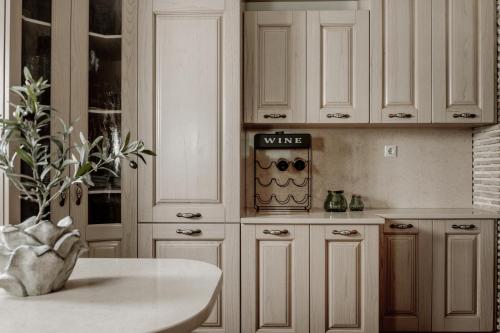 a kitchen with white cabinets and a vase with a plant at Amalthia Villa in Mouzákion