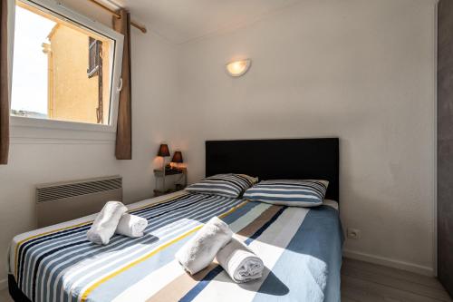 ein Schlafzimmer mit einem Bett mit Handtüchern darauf in der Unterkunft Kallistea - Appartement avec vue mer in Porticcio