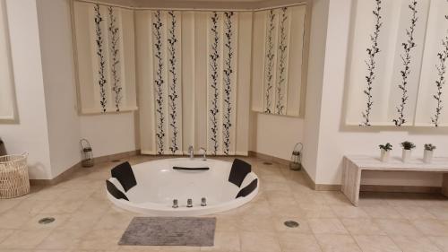 eine Badewanne in einem Zimmer mit Vorhängen in der Unterkunft Horská chata KorAlpe in Hartelsberg