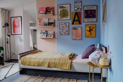 1 dormitorio con cama y pared con cuadros en sleepArt room for 3 en Celle