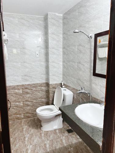 a bathroom with a toilet and a sink at Nhà Nghỉ Trường Lệ in Sầm Sơn