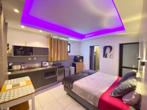 a bedroom with a large bed and a purple ceiling at Hostal 170 Room 14 Service Appartement in Le Tampon