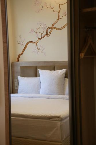a bedroom with a bed with a painting on the wall at KUMA Hotel Gyumri in Gyumri