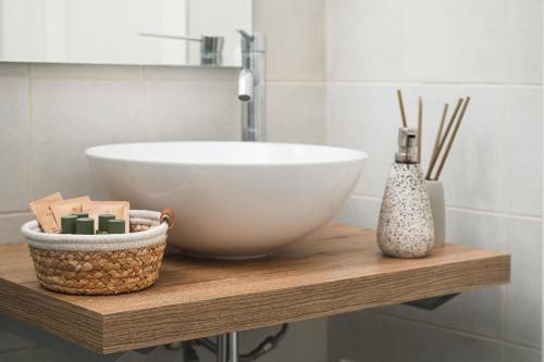 a bathroom with a sink and a bowl on a wooden shelf at i Cacciagalli Wine Resort in Teano