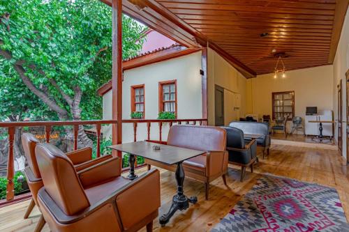 un porche cubierto con sillas y mesa en Sarı Konak, en Antalya