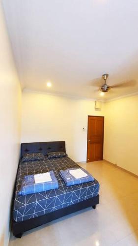 a bedroom with a bed with blue sheets and a ceiling at Puchong Semi D Homestay spacious 4 rooms in Puchong