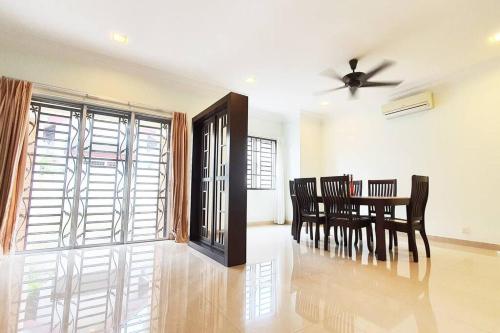 Puchong Semi D Homestay spacious 4 rooms في بوتشونغ: غرفة طعام مع طاولة وكراسي ومروحة سقف