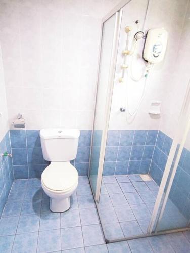 a blue tiled bathroom with a toilet and a shower at Puchong Semi D Homestay spacious 4 rooms in Puchong