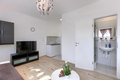 a white living room with a sink and a television at Hostel Monte Zaro in Pula