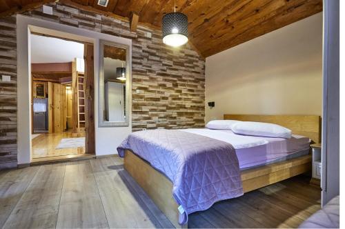 a bedroom with a bed and a brick wall at Holiday house with a parking space Krapina, Zagorje - 21000 in Krapina