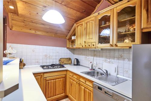 a kitchen with wooden cabinets and a sink at Holiday house with a parking space Krapina, Zagorje - 21000 in Krapina