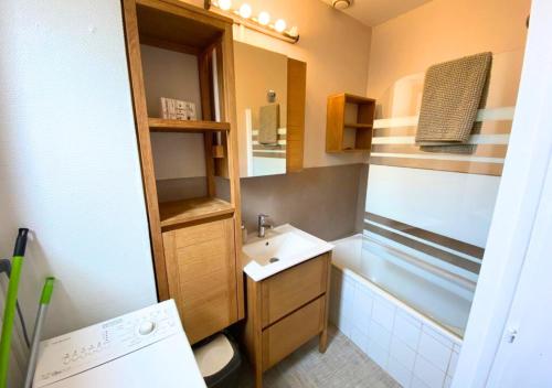 a small bathroom with a sink and a tub at La Comédie - Poitiers Centre - La Conciergerie. in Poitiers