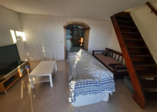 a room with a bed and a tv and a staircase at Panoramico nell'antico borgo medievale di Casperia in Casperia