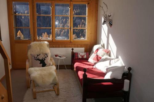 a living room with a couch and a chair and a window at Vue à couper le souffle Arellaz 42 in Zinal