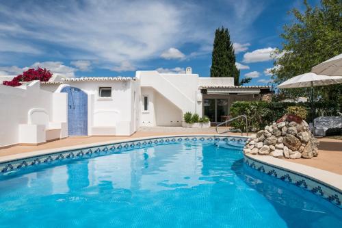 una piscina frente a una casa blanca en The Carobs Villas, en Carvoeiro