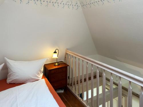 a bedroom with a bed and a lamp on a night stand at Friesenhof, Haus Hafis, Whg 9 in Nebel