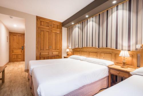 a bedroom with two beds and a table with a lamp at Snö Villa de Sallent 3 in Formigal