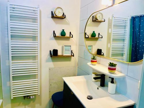 La salle de bains est pourvue d'un lavabo et d'un miroir. dans l'établissement Luxembourg City - 70m2 - Easy parking - Bus - 2 TVs - between City and Forest, à Luxembourg