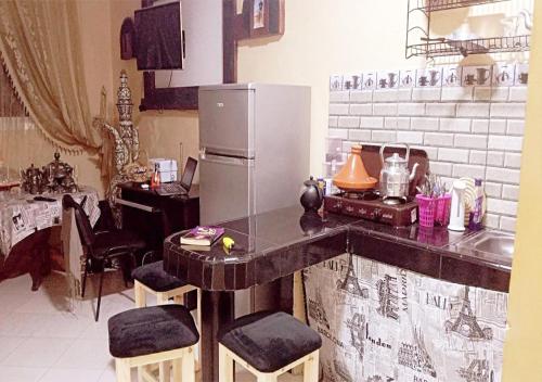 a kitchen with a counter with a refrigerator at Welcome in Appartement marocain proche de la mer à Sidi Bouzid in Safi