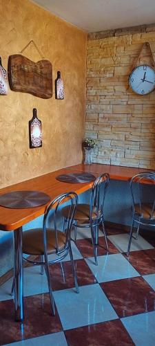 a restaurant with tables and chairs and a clock on the wall at Hostel Texas in Suwałki