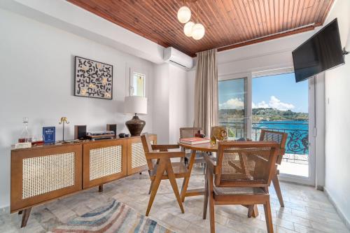 a dining room with a table and chairs and a television at Megaron Skiathos Boutique Residence in Skiathos Town