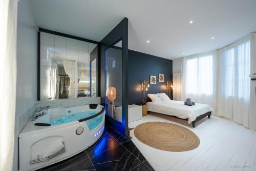 a bathroom with a tub and a bed in a room at LOFT Clim - Jacuzzi Centre Gare - Parking gratuit in Toulouse