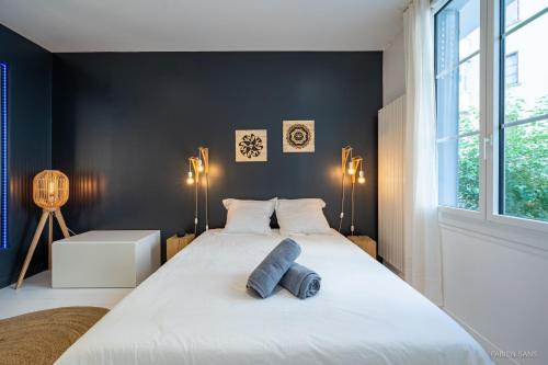 a bedroom with a large white bed and a window at LOFT Design Jacuzzi Centre Gare - Parking gratuit in Toulouse