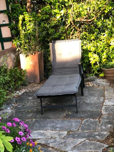 a chair sitting on a stone patio with flowers at Flower House - Lapad in Dubrovnik