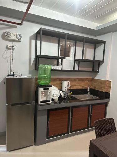 a small kitchen with a refrigerator and a sink at Block 7 Dormitelle - Balanga City in Balanga