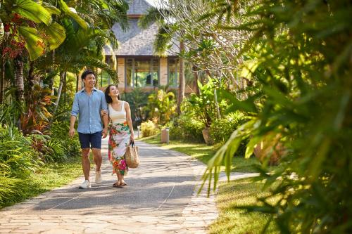 a man and a woman walking down a path at ROBINSON KHAO LAK in Khao Lak