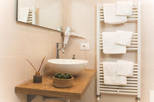 a bathroom with a sink and a mirror and towels at i Cacciagalli Wine Resort in Teano