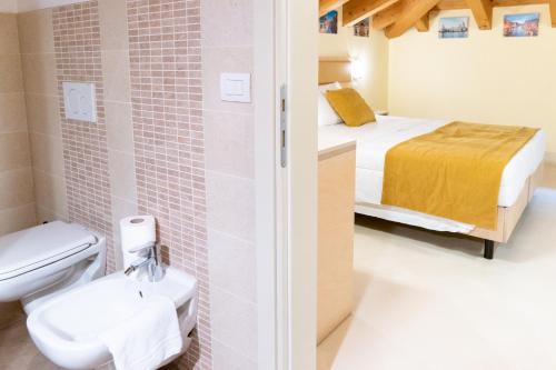un bagno con servizi igienici e un letto in una camera. di Hotel Autoespresso Venice a Marghera
