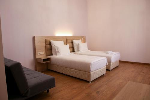 a hotel room with two beds and a couch at KUMA Hotel Gyumri in Gyumri