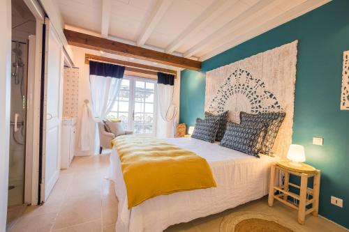 une chambre avec un lit et un mur bleu dans l'établissement Gîte du Domaine de Roujol, à Brassac