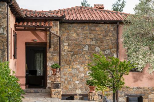 a brick house with a door and a tree at Stone-Home Living in Neos Marmaras