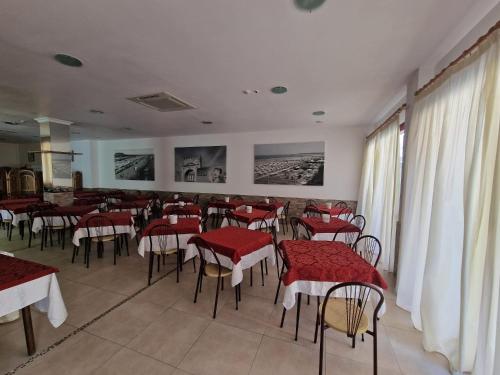a restaurant with red tables and chairs in a room at HOTEL CLARA RIMINI 30m from the beach in Rimini