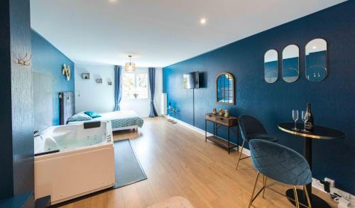 a bedroom with blue walls and a bed and a kitchen at * Spa & Détente # Suite Privée # Tours # Netflix * in Tours