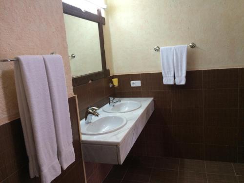 La salle de bains est pourvue de 2 lavabos, d'un miroir et de serviettes. dans l'établissement Villa O Sole Mio, à Progled